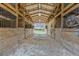 Open barn interior with stalls and a central walkway leading to the outdoors at 3634 Apfel Rd, Wesley Chapel, FL 33543