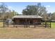 Exterior view of a horse barn with fenced pasture and trailer at 3634 Apfel Rd, Wesley Chapel, FL 33543