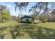 Rear of home and expansive lawn and mature trees showcases outdoor living at 3634 Apfel Rd, Wesley Chapel, FL 33543