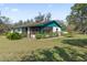 Charming home featuring a screened porch with lush landscaping and a well-maintained yard at 3634 Apfel Rd, Wesley Chapel, FL 33543