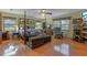 Spacious main bedroom with a four-poster bed, hardwood floors, and a ceiling fan at 3634 Apfel Rd, Wesley Chapel, FL 33543