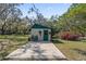 Versatile shed with patio, offering potential for storage or workspace, with mature trees at 3634 Apfel Rd, Wesley Chapel, FL 33543