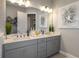 A full bathroom offering granite countertops, double sinks, and a large decorative mirror at 6243 Plateau Ct, Bradenton, FL 34203