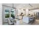 Modern kitchen and dining area with white cabinets, stainless steel appliances, and bar stool seating at 6243 Plateau Ct, Bradenton, FL 34203