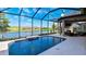 Stunning pool under a screened enclosure overlooking a lake and green space, and with an outdoor fireplace at 6243 Plateau Ct, Bradenton, FL 34203