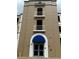 Exterior shot of a multi-story condo building with balconies and a blue awning over the entrance at 8111 Lakewood Main St # 207, Lakewood Ranch, FL 34202
