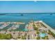 Expansive aerial view of a marina with numerous boats, surrounded by waterfront buildings, parking, and pools at 840 Virginia St # 202, Dunedin, FL 34698