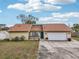 Home exterior featuring a large driveway and well-kept lawn at 3019 Woodpine Ln, Sarasota, FL 34231