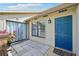 Inviting front entrance featuring a blue door, tiled patio, and decorative potted plants at 3019 Woodpine Ln, Sarasota, FL 34231