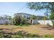 A home borders a white fence with overgrown landscaping. A trailer sits in disrepair at 3962 Poinsettia Dr, St Pete Beach, FL 33706