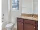 Bathroom with a vanity with granite countertop and wood cabinets and a toilet next to a bathtub at 5954 Caldera Ridge Dr, Lithia, FL 33547