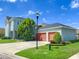 Two story home with a three car garage, green lawn and mature trees at 5954 Caldera Ridge Dr, Lithia, FL 33547
