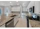 Modern kitchen with white cabinetry, stainless steel appliances, and granite countertops at 5954 Caldera Ridge Dr, Lithia, FL 33547