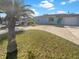 Charming single-story home with fresh grass, palm trees, and a blue front door at 8340 75Th Pl, Seminole, FL 33777