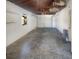 Unfinished garage with open rafters, concrete floor, and white door at 8340 75Th Pl, Seminole, FL 33777