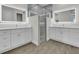 Luxury bathroom boasts double vanity, stone counters, illuminated mirrors, and glass shower at 15741 Autry Cir, Port Charlotte, FL 33981