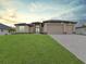 Charming single-story home featuring a well-manicured lawn and three-car garage at 15741 Autry Cir, Port Charlotte, FL 33981