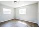 Bedroom with panel walls, hardwood flooring, and two bright windows at 1907 Lakewood Dr, Clearwater, FL 33763