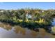 Waterfront home surrounded by mature trees, private boat dock, and serene views of bay at 5275 Miller Bayou Dr, Port Richey, FL 34668