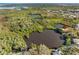 Expansive aerial view of a waterfront property on a lake, surrounded by lush foliage and serene waters at 5275 Miller Bayou Dr, Port Richey, FL 34668