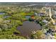 Scenic aerial view of a waterfront home on a lake with dock access, surrounded by lush greenery at 5275 Miller Bayou Dr, Port Richey, FL 34668