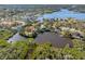 Stunning aerial view of waterfront home with lush surroundings and private dock on a calm lake at 5275 Miller Bayou Dr, Port Richey, FL 34668