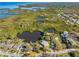 Scenic aerial shot of waterfront property with lush trees, dock, and calm waters perfect for waterfront living at 5275 Miller Bayou Dr, Port Richey, FL 34668