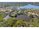 Picturesque aerial view of home with a dock, nestled on a tranquil lake surrounded by mature trees at 5275 Miller Bayou Dr, Port Richey, FL 34668