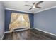 Bedroom features hardwood floors, a ceiling fan, and a window with curtains at 13794 Marseilles Ct, Clearwater, FL 33762