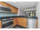 Contemporary kitchen showcasing granite countertops, stainless steel appliances, and wood cabinets at 13794 Marseilles Ct, Clearwater, FL 33762