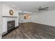 Open living room with wood flooring, a fireplace, and a glimpse of the open kitchen at 13794 Marseilles Ct, Clearwater, FL 33762