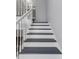 Clean and simple staircase with white rails, dark gray treads, and white risers at 13794 Marseilles Ct, Clearwater, FL 33762