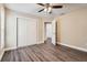 Bedroom with ceiling fan, neutral walls, closet, and luxury vinyl plank flooring at 7001 Heath Dr, Port Richey, FL 34668