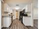 Well-lit kitchen with granite countertops, white cabinets, stainless steel dishwasher and luxury vinyl plank flooring at 7001 Heath Dr, Port Richey, FL 34668