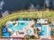 Overhead shot of a community pool area, featuring a large freeform pool, lap pool, and plenty of lounge chairs at 4949 Sandy Glen Way, Wimauma, FL 33598
