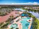 A community pool, clubhouse, and beautiful landscaping offer a resort-like atmosphere in this aerial view at 4949 Sandy Glen Way, Wimauma, FL 33598