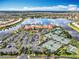 Aerial view of a large community clubhouse featuring a pool, tennis courts, and ample parking at 4949 Sandy Glen Way, Wimauma, FL 33598