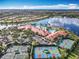 Overhead view highlighting community amenities: clubhouse, pools, and tennis courts, all set along a serene lake at 4949 Sandy Glen Way, Wimauma, FL 33598