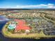 Overhead shot of community amenities including swimming pools, tennis courts and a clubhouse, surrounded by a lake at 4949 Sandy Glen Way, Wimauma, FL 33598