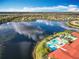 An aerial perspective of a beautiful lake community with a pool and clubhouse, showcasing the neighborhood's appeal at 4949 Sandy Glen Way, Wimauma, FL 33598