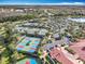 A picturesque aerial view of the community tennis courts, parking, and clubhouse, offering resort-style living at 4949 Sandy Glen Way, Wimauma, FL 33598