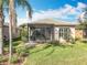 Lush backyard showcasing the screened lanai and mature landscaping at 4949 Sandy Glen Way, Wimauma, FL 33598