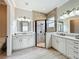 Bathroom featuring double sinks, white cabinetry, and a glass shower at 4949 Sandy Glen Way, Wimauma, FL 33598