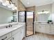 Bathroom featuring double sinks, white cabinetry, and a glass shower at 4949 Sandy Glen Way, Wimauma, FL 33598