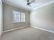 Neutral bedroom featuring a large window with blind and a ceiling fan at 4949 Sandy Glen Way, Wimauma, FL 33598