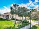 Beautiful exterior showcasing the home's lush lawn, palm trees and barrel tile roof at 4949 Sandy Glen Way, Wimauma, FL 33598