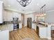 Bright kitchen with white cabinets, granite countertops, stainless steel appliances, and a stylish chandelier at 4949 Sandy Glen Way, Wimauma, FL 33598