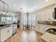 Modern kitchen with white cabinetry, granite countertops, and stainless steel appliances, adjacent to a dining area at 4949 Sandy Glen Way, Wimauma, FL 33598