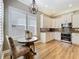 Cozy kitchen nook with natural light, featuring white cabinets, stainless steel appliances, and modern lighting at 4949 Sandy Glen Way, Wimauma, FL 33598