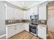 Well-equipped kitchen featuring white cabinets, granite countertops, and stainless steel appliances for culinary enthusiasts at 4949 Sandy Glen Way, Wimauma, FL 33598
